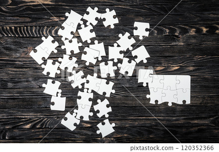 white puzzle pieces on dark table white puzzle pieces on dark table 120352366
