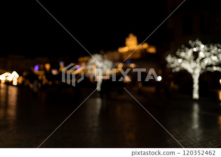 Abstract Christmas street background of garland lights in the dark. Christmas lights defocused. Abstract Christmas street background of garland lights in the dark. Christmas lights defocused. 120352462