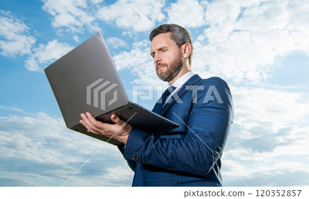 freelancer man type on laptop on sky background. freelancer man with laptop outdoor freelancer man type on laptop on sky background. freelancer man with laptop outdoor 120352857