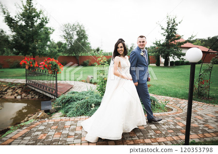 Happy wedding couple walking in a botanical park Happy wedding couple walking in a botanical park 120353798
