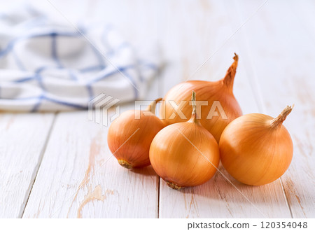 Yellow onions on a wooden table, selective focus. Copy space for text. 120354048