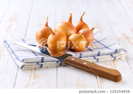 Yellow onions on a wooden table, selective focus. Copy space for text. Yellow onions on a wooden table, selective focus. Copy space for text. 120354056
