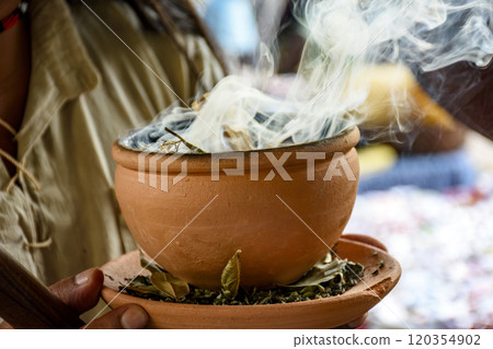 Herbs burning from a clay pot 120354902