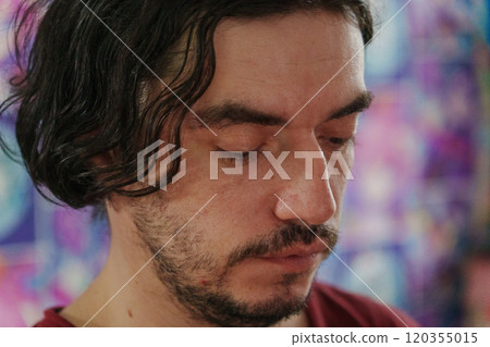 Man with tousled hair gazes thoughtfully into the distance amidst a lively atmosphere Man with tousled hair gazes thoughtfully into the distance amidst a lively atmosphere 120355015