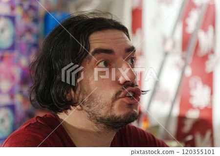Man displays a look of astonishment, reflecting the excitement of an ongoing local festival filled with bright colors and energy. Man displays a look of astonishment, reflecting the excitement of an ongoing local festival filled with bright colors and energy. 120355101
