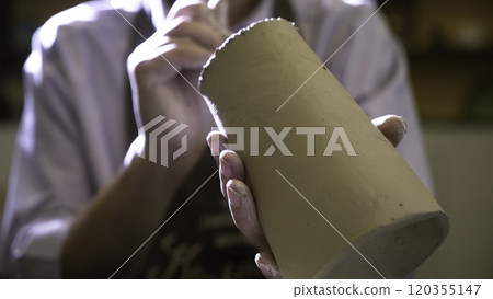 An Artisan Expert Focused on Crafting a Stunning Ceramic Piece with Skillful Precision. Stock Clip An Artisan Expert Focused on Crafting a Stunning Ceramic Piece with Skillful Precision. Stock Clip 120355147