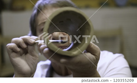 An artisan potter presents a unique handmade clay cylinder with intricate design and craft. Stock Clip An artisan potter presents a unique handmade clay cylinder with intricate design and craft. Stock Clip 120355209