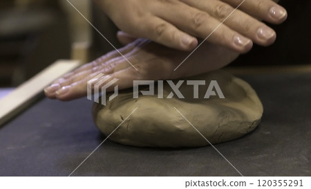 Hands are skillfully shaping clay in a pottery workshop where creativity blends with craft. Stock Clip 120355291