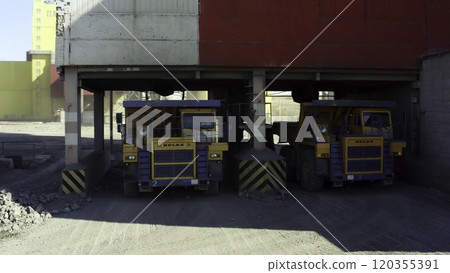 Heavy Dump Trucks lined up and waiting at the Loading Dock for their next assignment. Stock Clip 120355391