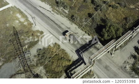 An aerial view of a winding dirt road and a vehicle in a scenic rural landscape. Stock Clip 120355398