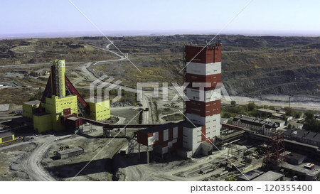 Aerial view of a modern mining facility with red and yellow structures and landscape. Stock Clip 120355400
