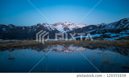 Sunset over the Pyrenees mountains with the reflection of the peaks in the water of the lake 120355839