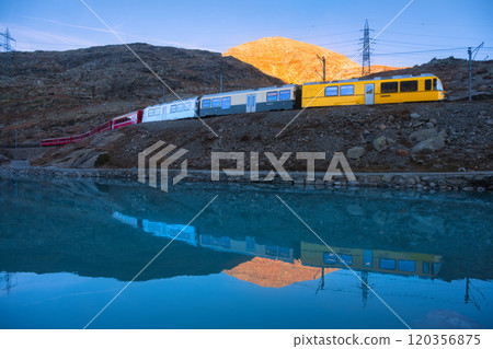 Bernina express train and alpine lake with colorful reflections 120356875