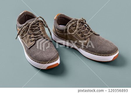 Khaki canvas shoes over silver blue background. 120356893