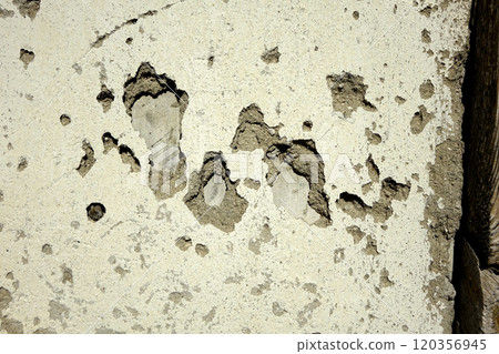 Detailed View of a Textured Plaster Wall With Weathered Patches and Exposed Layers in Natural Light 120356945