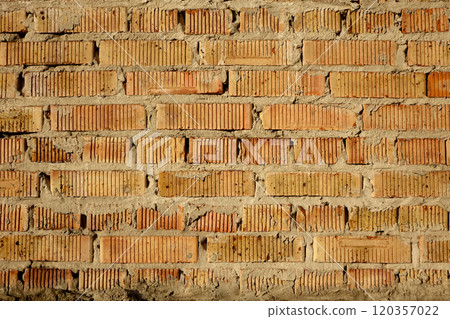 Multi-row masonry of light red bricks with vertical groove texture. Ugly mortar joints 120357022