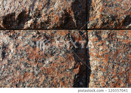 Red granite bricks masonry wall with grooves in the shape of a cross Red granite bricks masonry wall with grooves in the shape of a cross 120357041