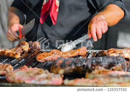 Chef Grilling Steaks Over Open Flame 120357592