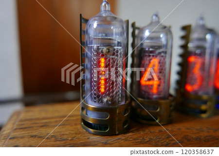 Retro Nixie lamp indicator clock on dark background. The Nixie tube indicator of the numbers of retro style. Retro Nixie lamp indicator clock on dark background. The Nixie tube indicator of the numbers of retro style. 120358637