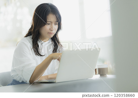Woman operating a personal computer 120358660