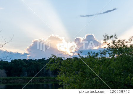 A stunning sunset and God's rays over a local MN lake with lots of greenery. 120359742
