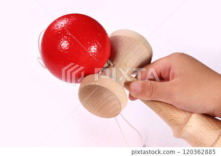 Child's hand holding a kendama 120362885