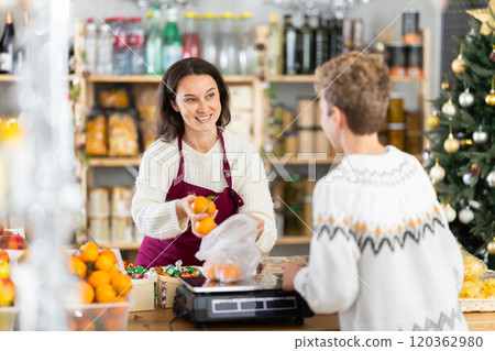 Female seller weighs tangerines for boy buyer Female seller weighs tangerines for boy buyer 120362980