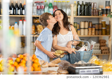 Adult woman with son choosing groceries in store Adult woman with son choosing groceries in store 120362981