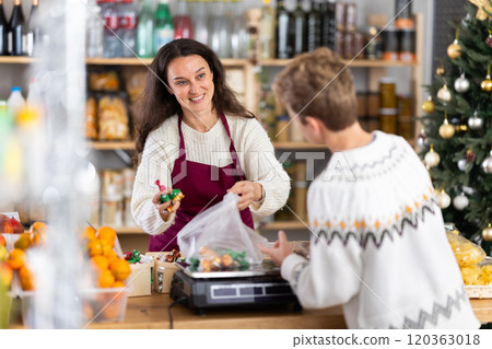 Woman sells sweets to teen boy, puts them on scale and weighs sweets, New Year Eve Woman sells sweets to teen boy, puts them on scale and weighs sweets, New Year Eve 120363018