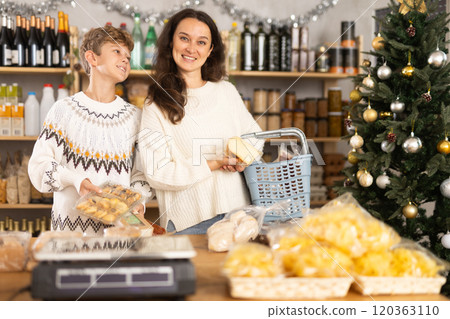 Mother and her son choose different products together for Christmas celebration in grocery supermarket Mother and her son choose different products together for Christmas celebration in grocery supermarket 120363110