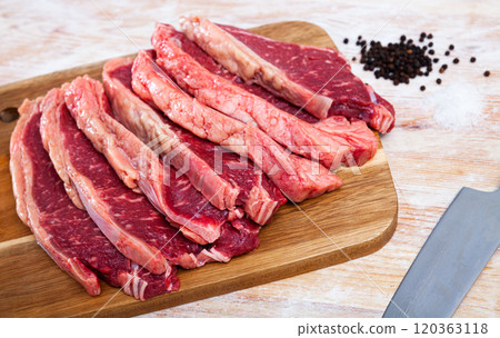 Raw marbled beef steaks with condiments on wooden table 120363118