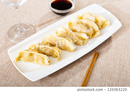 Delicious boiled gyoza dumplings, supplemented with necessary chopsticks and spicy soy sauce Delicious boiled gyoza dumplings, supplemented with necessary chopsticks and spicy soy sauce 120363220