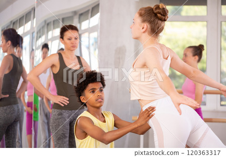 African American teen boy assisting girl in maintaining arabesque African American teen boy assisting girl in maintaining arabesque 120363317