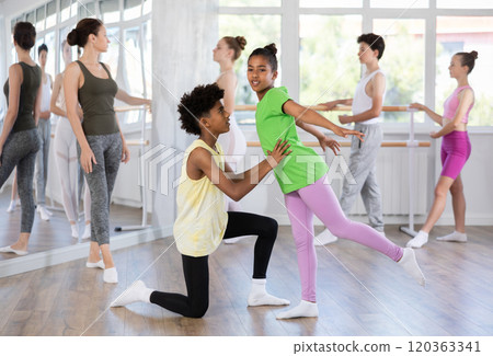 Teenage boy and girl doing together arabesque position of ballet during choreography classes Teenage boy and girl doing together arabesque position of ballet during choreography classes 120363341