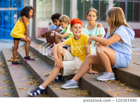 Group of kids sitting on stairs outdoors and talking Group of kids sitting on stairs outdoors and talking 120363490