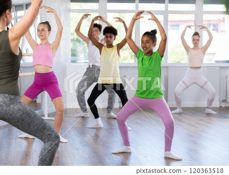 African american teen girl participating in beginner group ballet class African american teen girl participating in beginner group ballet class 120363518