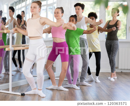 Teenage girl practicing plie position of ballet during choreography classes 120363571