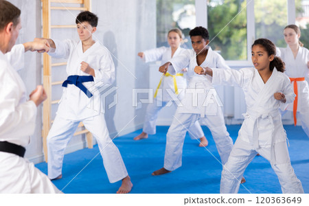 Group of children train karate techniques 120363649
