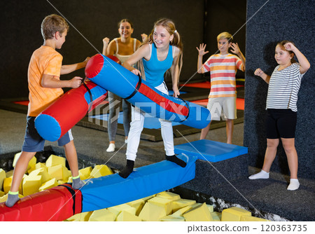 Children having funny wrestling by inflatable logs in indoor amusement park Children having funny wrestling by inflatable logs in indoor amusement park 120363735