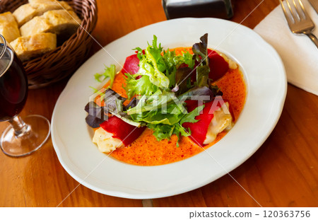 Tasty stuffed piquillo peppers with cod brandade in sauce 120363756