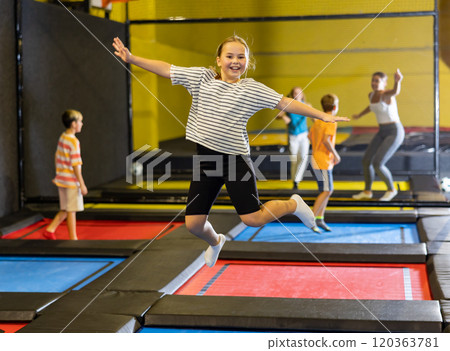 Tween girl having fun jumping in indoor trampoline arena 120363781