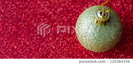 Golden Christmas ball on red background with customizable space for text or for wishes. Christmas celebration concept. 120364356