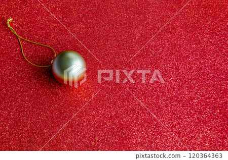 Top view of Golden Christmas ball on red background with customizable space for text or for wishes. 120364363
