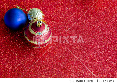 Top view of multicolored Christmas balls on red background with customizable space for text or for wishes. 120364365
