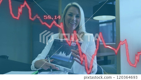 Financial data image over businesswoman reviewing documents in office 120364693