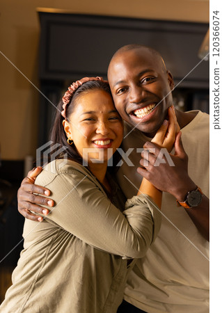Smiling multiracial couple embracing each other, enjoying quality time at home Smiling multiracial couple embracing each other, enjoying quality time at home 120366074