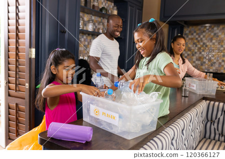 Sorting waste together, family recycling plastic bottles in kitchen Sorting waste together, family recycling plastic bottles in kitchen 120366127
