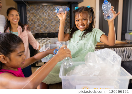 Recycling plastic bottles, children smiling and helping in kitchen with family 120366131