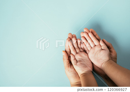 Close-up top view of family hands stack isolated background. Parents and kid hold empty space symbolizing support and love on Family and Parents Day. 120366927
