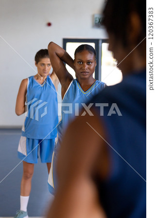 Playing basketball, female athletes in blue jerseys warming up on court Playing basketball, female athletes in blue jerseys warming up on court 120367383